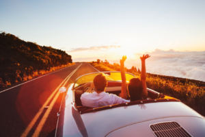 Image of couple driving in convertible.